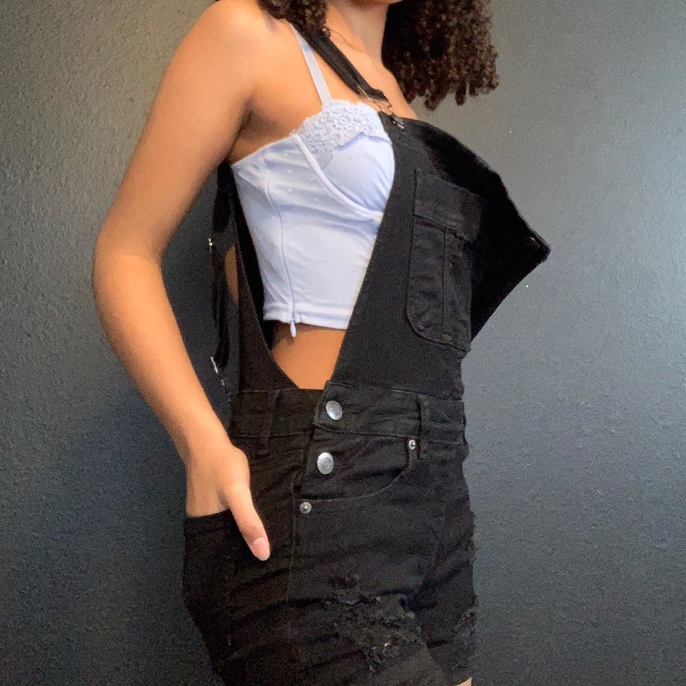 Black ripped overall shorts.